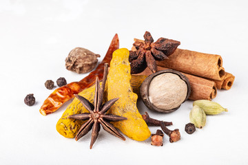 Dry warming Indian spices for autumn and winter meal on white concrete background.