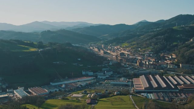 4K Aerial Basque Country industrial town in rural environment, beautiful valley and green fields