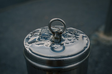 Stainless steel bollard in the city with a poorly welded round ring for a chain on it