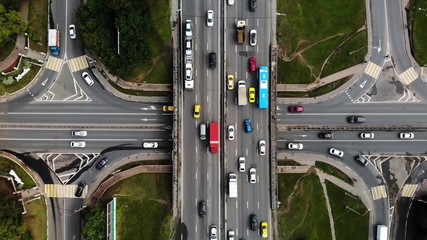 Top view of a city intersection with buses, cars, trucks. Traffic at daytime, roadcross in the megapolis. Going forward with cars.