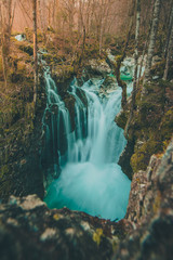 Beautiful water cascades or small waterfall in the valley of Lepena in Slovenian Julian Alps. Emerald green waterfalls in an enchanted forest.