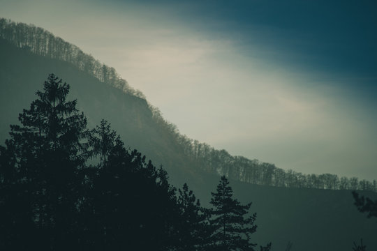 Fading hills in a distance. Series of tree lines and hills dissolving into the blue sky. Good for background.