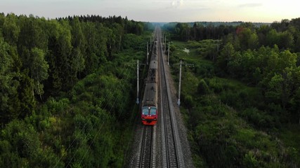 Aerial view: train at the rural scene in summer. The train rides through the rural countryside in...