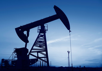 Oil pumps at work, silhouetted against the setting sun