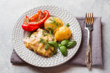 Baked potatoes with chicken and vegetables on a plate.
