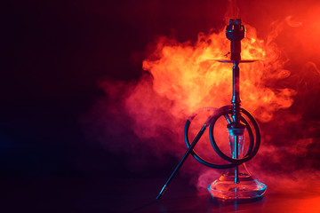 hookah shisha with glass flask and metal bowl with colored smoke on a black background - obrazy, fototapety, plakaty