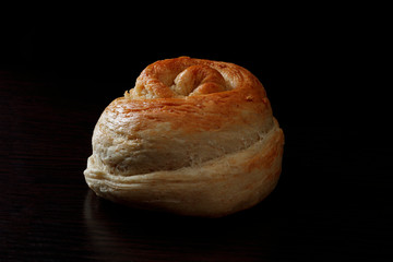 Freshly baked homemade buckwheat flour and whole grain corn bread. Bread sprinkled with oat flakes on a dark background. Healthy gluten free food. Low key photo