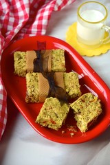 Breakfast granola bars made from oat, goji berry, pumpkin seed, sunflower seed, date, brazil nuts and sesame seeds served with milk
