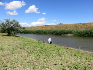 Fishing on the river on a clear summer day.