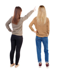 Back view of two pointing girl in sweater.