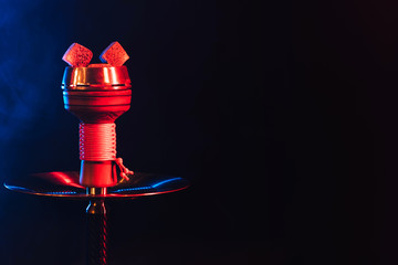 red hot coals of a hookah in a shisha bowl on a black background