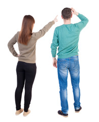 Back view of couple in sweater pointing.