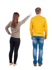 Back view of couple in sweater pointing.