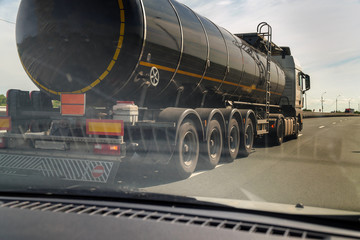 A fuel truck is driving on an asphalt road