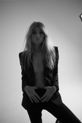 Studio black and white photo model girl in men suit