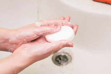Fototapeta premium Foaming soap. A woman washes her hands to destroy the coronavirus virus. Influenza Prevention