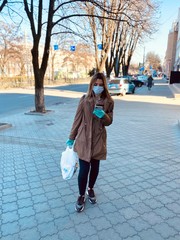 Young model in a protective mask and gloves against coronavirus in a pharmacy.  smartphone in hand. Covid 2019. Covid 2020.