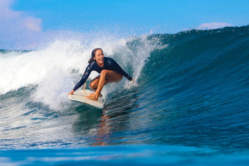 Female surfer on a blue wave - 331424504