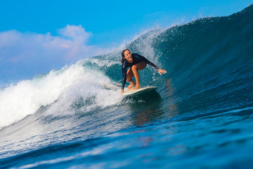Female surfer on a blue wave - 331424766