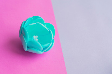 Artificial peony on a bright colored background.