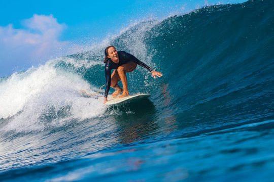 Female surfer on a blue wave