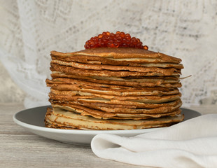 Homemade thin fresh crepes with red caviar for breakfast or dessert. Close up