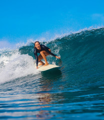 Female surfer on a blue wave - 331425153