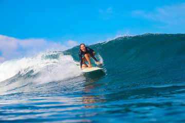 Female surfer on a blue wave
