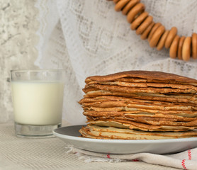 Homemade thin fresh crepes with a glass of milk and hand bagels . Close up