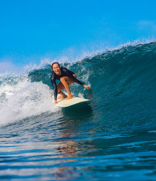 Female surfer on a blue wave