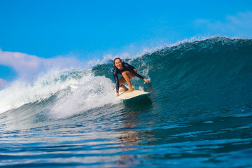 Female surfer on a blue wave