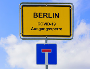 Ausgangssperre wegen Coronavirus steht auf Ortsschild für Berlin