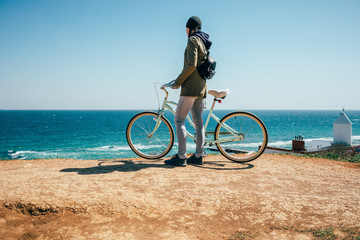 Fototapeta premium Young woman standing next to her bike