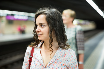 Woman commuter waiting train on public transport station