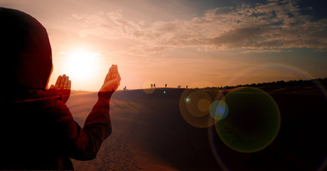 double exposure image, Silhouette of women praying for a new day freedom on desert, hand praying for thank GOD. Add lens flare.
