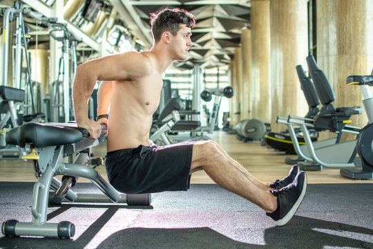 Handsome Young Shirtless Guy Doing Bench Dips Exercises At Gym