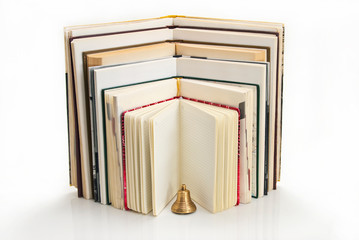 Books in expanded form with a bell.