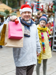 Smiling man in Santa hat with bags