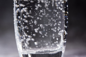 Glass of sparkling water on the grey background