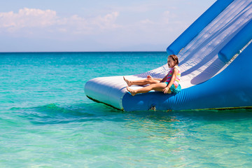 Kids on trampoline on tropical sea beach.