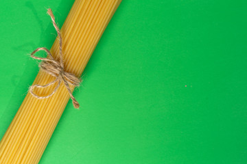 spaghetti on a green background, tied with a rope,. copy space