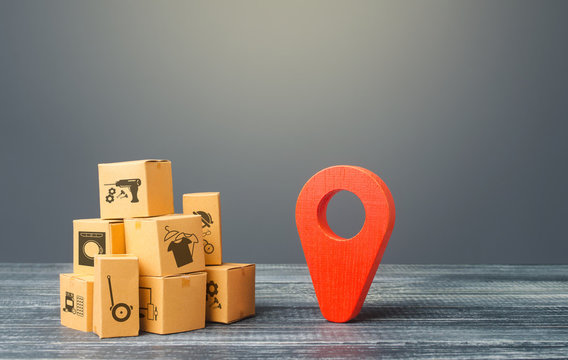 Red location pointer geolocation symbol and cardboard boxes. Global market and business, import and export. Distribution delivery of goods, freight transportation shipment. Logistics and warehousing.