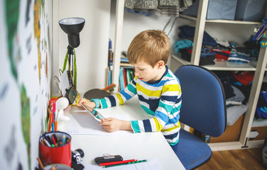 Boy typing on digital tablet