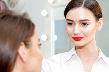 Makeup artist looks on client.