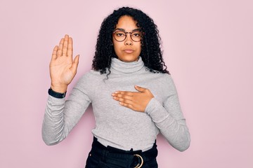Young african american woman wearing turtleneck sweater and glasses over pink background Swearing...