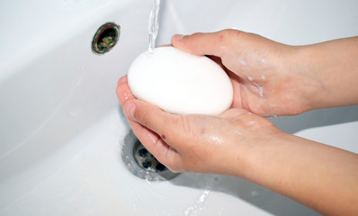 Children's hands under the tap with water, the child washes his hands.