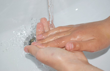 Fototapeta premium Children's hands under the tap with water, the child washes his hands.