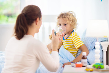 Sick little boy with asthma medicine. Ill child.