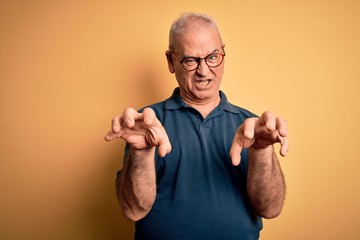 Middle age handsome hoary man wearing casual polo and glasses over yellow background smiling funny...