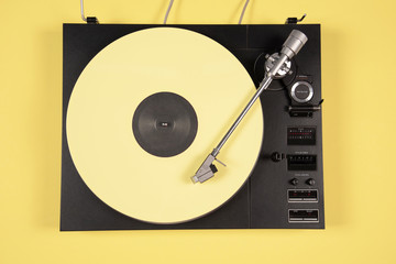 Obraz premium Colored vinyl record on a yellow background with copy space.